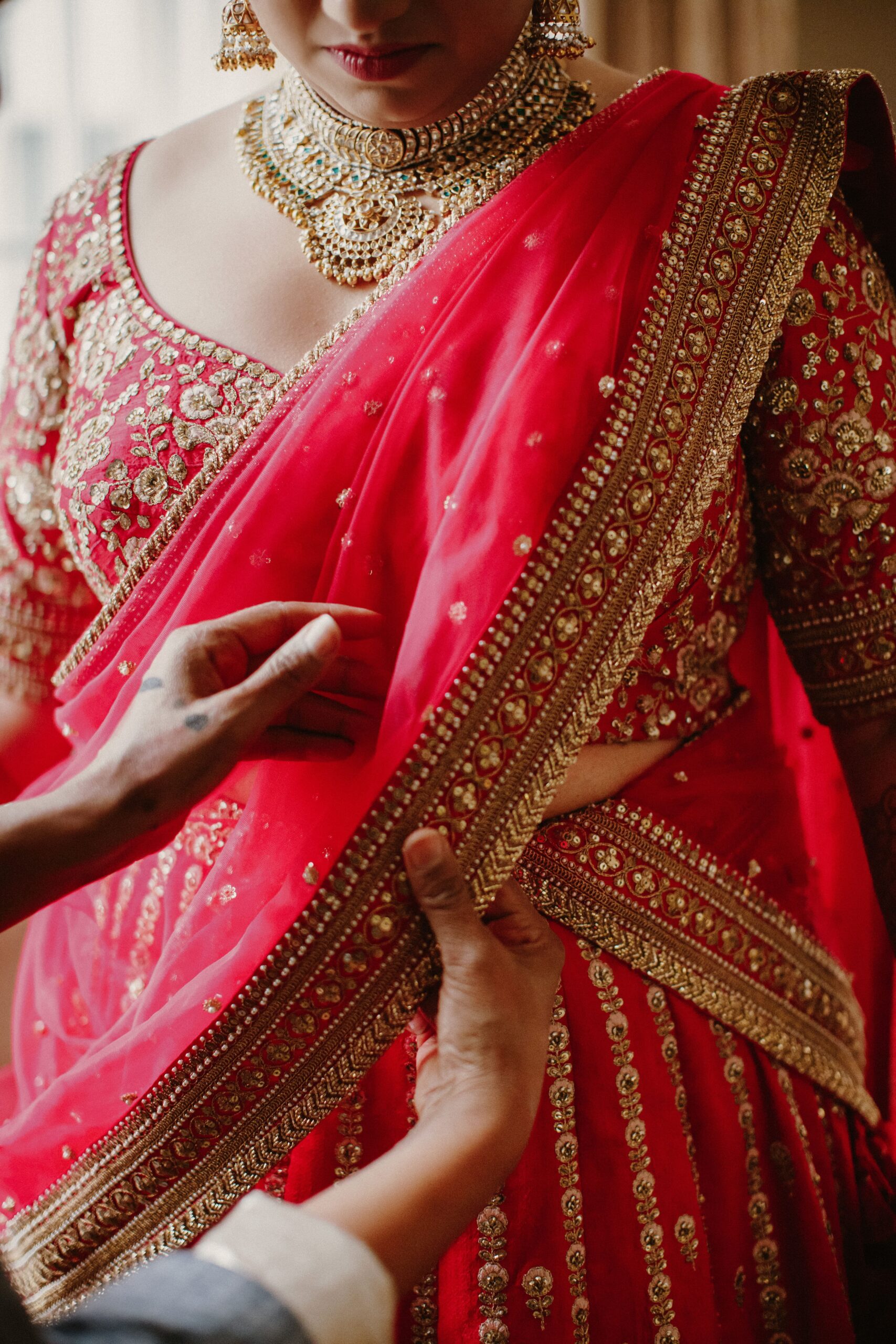 bridesmaid-helps-wear-traditional-indian-bride-dress